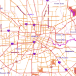 Houston metro area map with vibrant pink and orange road networks. Major highways including I-10, I-45, I-69, and Loop 610 are highlighted in bright red and purple. Surrounding communities are labeled, including Katy to the west, Jersey Village and Forest Acres to the north, Channelview and Galena Park to the east, and Bellaire, Pasadena, and Missouri City to the south. The map shows Houston's sprawling grid system with waterways marked in pink outlines.